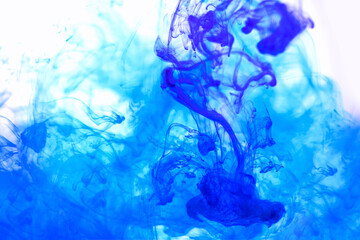 Bright blue and mint acrylic paint swirling in water. Ink moving in liquid creating abstract clouds. Traces of colorful dissolving in water, changing shape. Abstract decorative creative background.