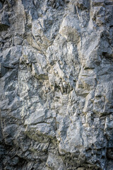 Rough rock face texture with high contrast and warm highlight, cool shadows