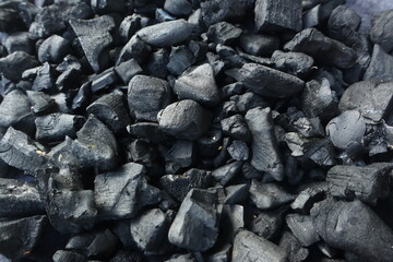 Dark coal texture, the remnants of wood burning into charcoal that can be used for barbecue