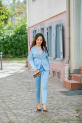 Portrait of a beautiful young woman in a blue suit with a bouquet of tulips. Spring.
