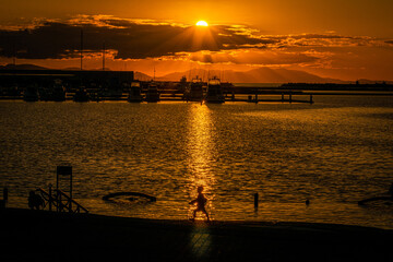 黄昏の海辺のこどものシルエット