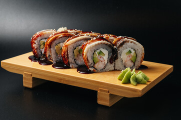 sushi roll with eel and shrimp on wooden board © Илья Солдаткин