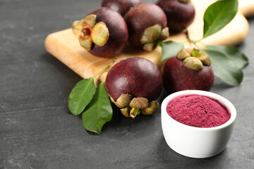 Purple mangosteen powder and fruits on black table