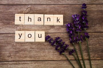 Thank you  message in wooden tiles, letters, with fresh lavender on rustic wooden background, flat lay