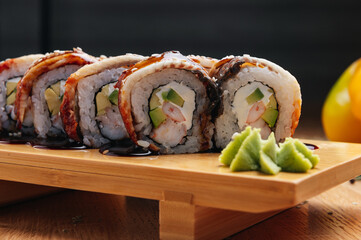 sushi roll with eel and shrimp on wooden board