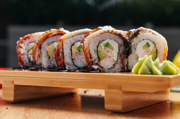 sushi roll with eel and shrimp on wooden board