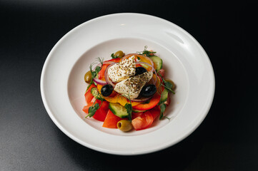 Close up of Greek salad with fresh vegetables, feta cheese and olives in a plate. Vegetarian healthy food diet