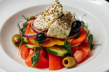 Close up of Greek salad with fresh vegetables, feta cheese and olives in a plate. Vegetarian healthy food diet