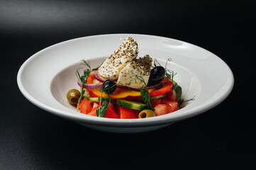 Close up of Greek salad with fresh vegetables, feta cheese and olives in a plate. Vegetarian healthy food diet
