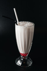Closeup glass of milk shake isolated on black background