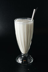 Closeup glass of milk shake isolated on black background