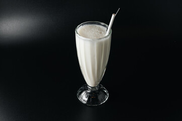 Closeup glass of milk shake isolated on black background