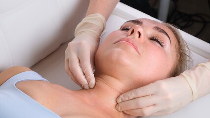 Chin massage of woman young woman during face massage at beauty salon - obrazy, fototapety, plakaty