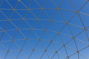 Steel polygon frame shell structure against blue sky