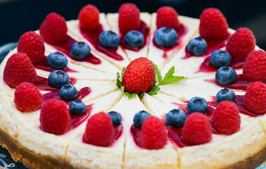 Close up view of a delicious cheesecake ready to be served as a desert with forest fruits on top of it.