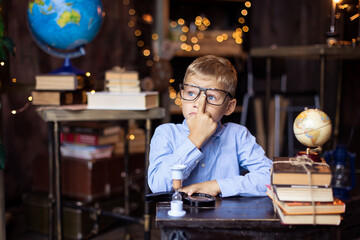 schoolboy puts on glasses. Back to school concept. A boy nerd in a  uniform. Primary School. Home...