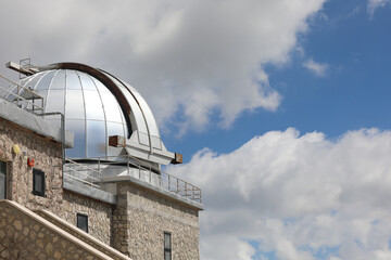 steel dome with the telescope of the astronomical observatory in the mountains for the observation...