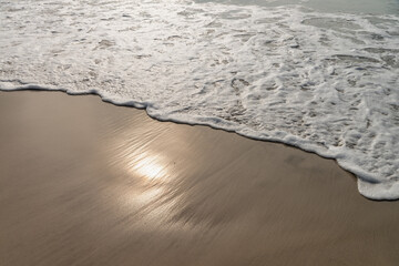 Sand surface covered with water layer from coming waves