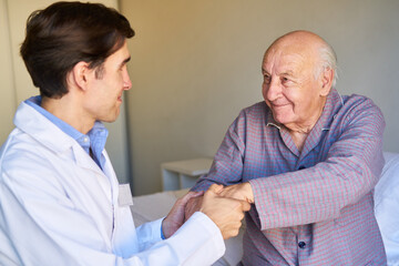 Geriatric nurse helps senior get up in the nursing home