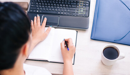 The concept of a working house is a girl at a laptop and business reports, there is a coffee mug...