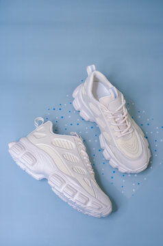 White Chunky Sole Sneakers On A Blue Background
