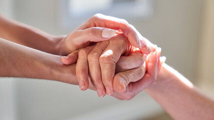 Hands held by senior woman for assistance in hospice