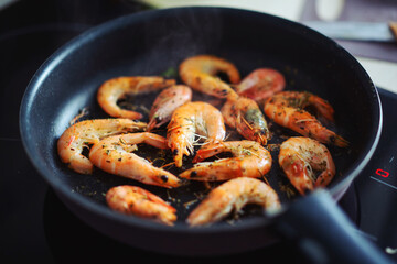 Frying shrimps with spices on skillet