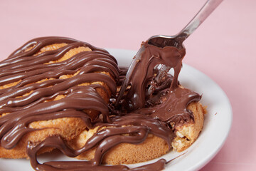 fresh pancake in a plate poured with chocolate paste, cream on buns, pancakes with chocolate