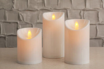 Fototapeta na wymiar Decorative LED candles on white wooden table