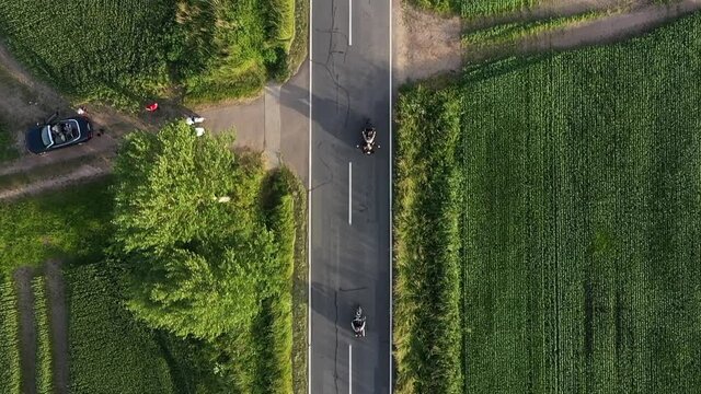 Two motorcycles are driving fast along the highway outside the city, aerial footage 