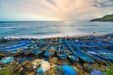 Rows of blue fishing boats on Menganti beach, Central Java 
