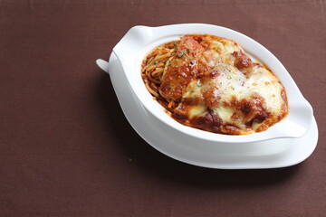 oven baked creamy cheese tomato Bolognese pasta with grilled chicken chop in bowl western chef cuisine seafood menu in white and brown background