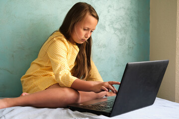 Little girl learns from a laptop computer