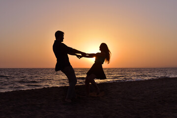 Silhouette of a Young Couple on the Beach at Sunset