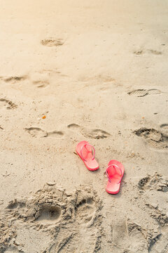 A pair of flip-flops on a sandy beach on Atlantic ocean