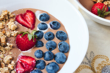 Strawberry and blueberry with breakfast granola in cocoa cream yoghurt