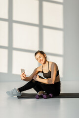 Happy athletic woman make selfie photo or vlogging on phone during fitness training. Healthy lifestyle, social activity on the Internet about sports