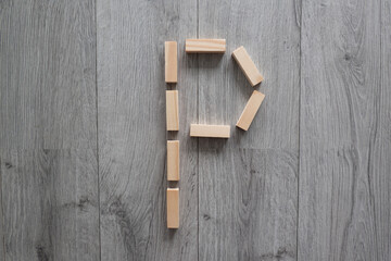 letter P natural wooden blocks on floor alphabet lettering