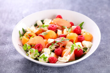 summer salad with melon,  raspberries, prosciutto ham and mozzarella