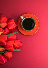 Bouquet of red  tulips and coffee cup arrangement with a lot of copy space for text. Spring mood concept. Greeting card for Birthday, Woman, Mother's Day, Wedding, Valentines day.