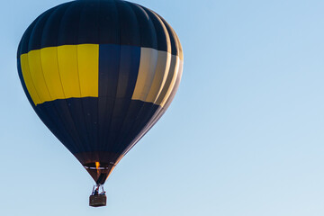 Hot Air Balloon on a blue sky.One Blue yellow hot air balloon in blue clear sky.Copy space.