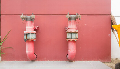 metal piping system on red concrete wall