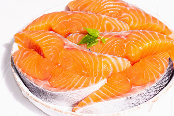 Fresh raw salmon or trout fish fillet steaks. Minimalistic design, modern hard light, dark shadow