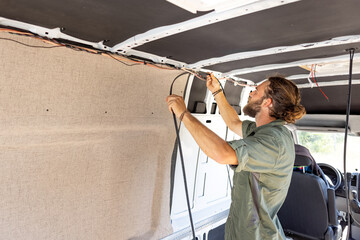 Man laying cable inside a camper van