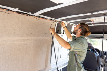 Man laying cable inside a camper van
