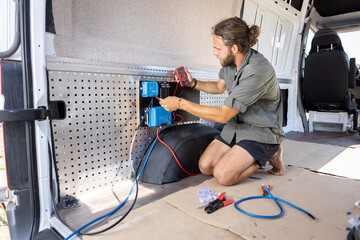 Man working on electronics inside a camper van