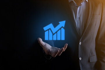 Businessman man holding a graph with positive profits growth. plan graph growth and increase of chart positive indicators in his business.more profitable and growing.