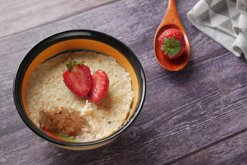 oats flakes and strawberry on wooden table 