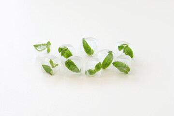 Ice cubes with mint leaves on white background. Copy space. © Vasylyna Maksymovych