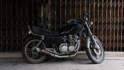 Obraz na płótnie Canvas Vintage motorcycle parking near ancient door house.
